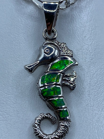 Dije caballito de mar sobre escala de centimetros, midiendo 4.6 cm de largo
