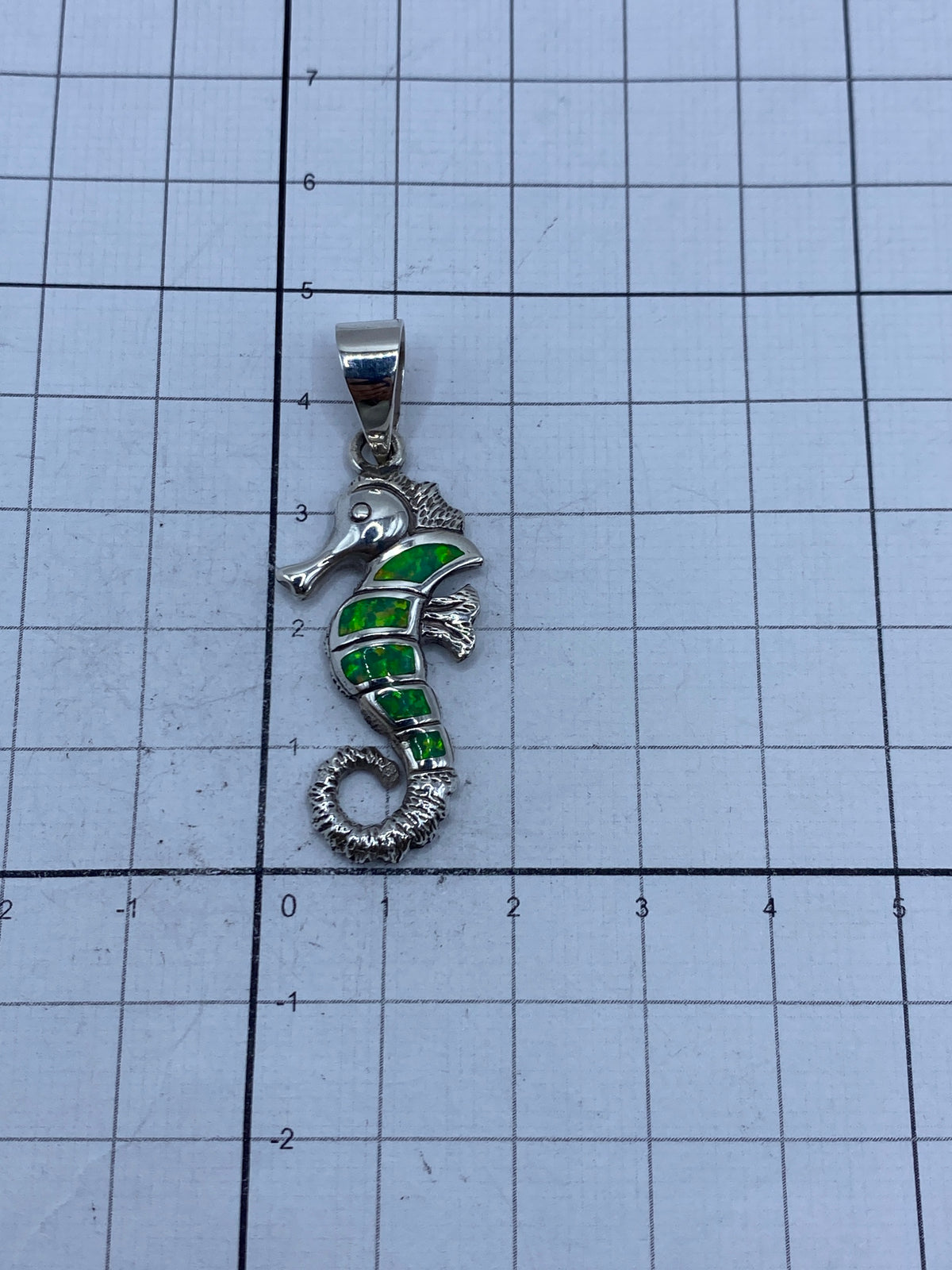 Reverso del dije caballito de mar mostrando el pulido y la solidez de la plata 950