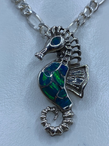 Dije caballito de mar en plata 950 con ópalo de fuego azul, vista frontal