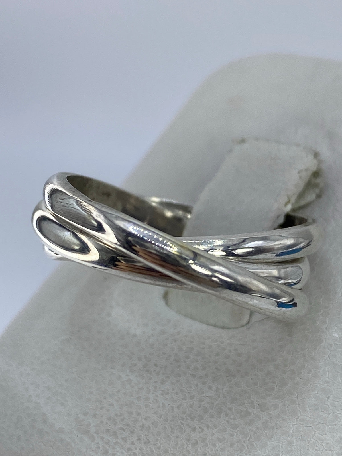 Detalle lateral del anillo de tres bandas mostrando el entrecruzado de la plata