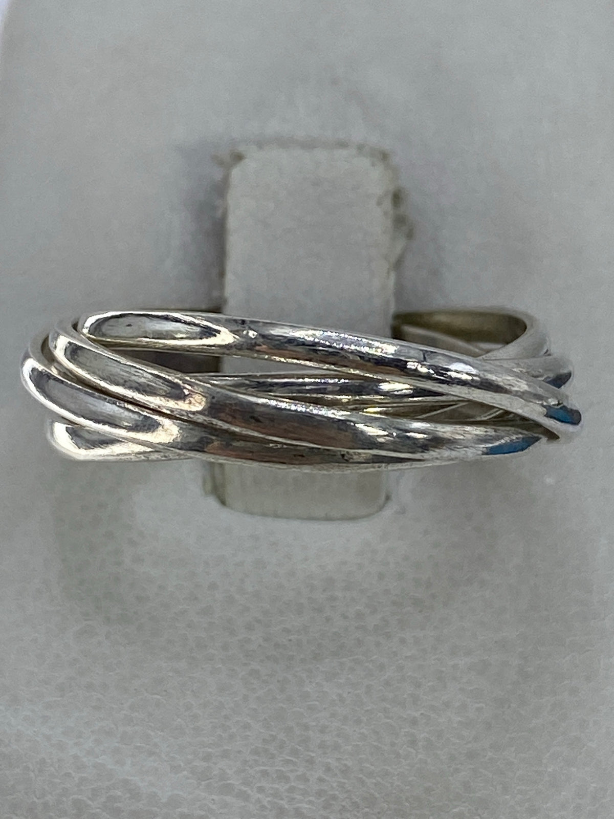 Anillo de plata con 5 bandas entrelazadas en la mano de una persona