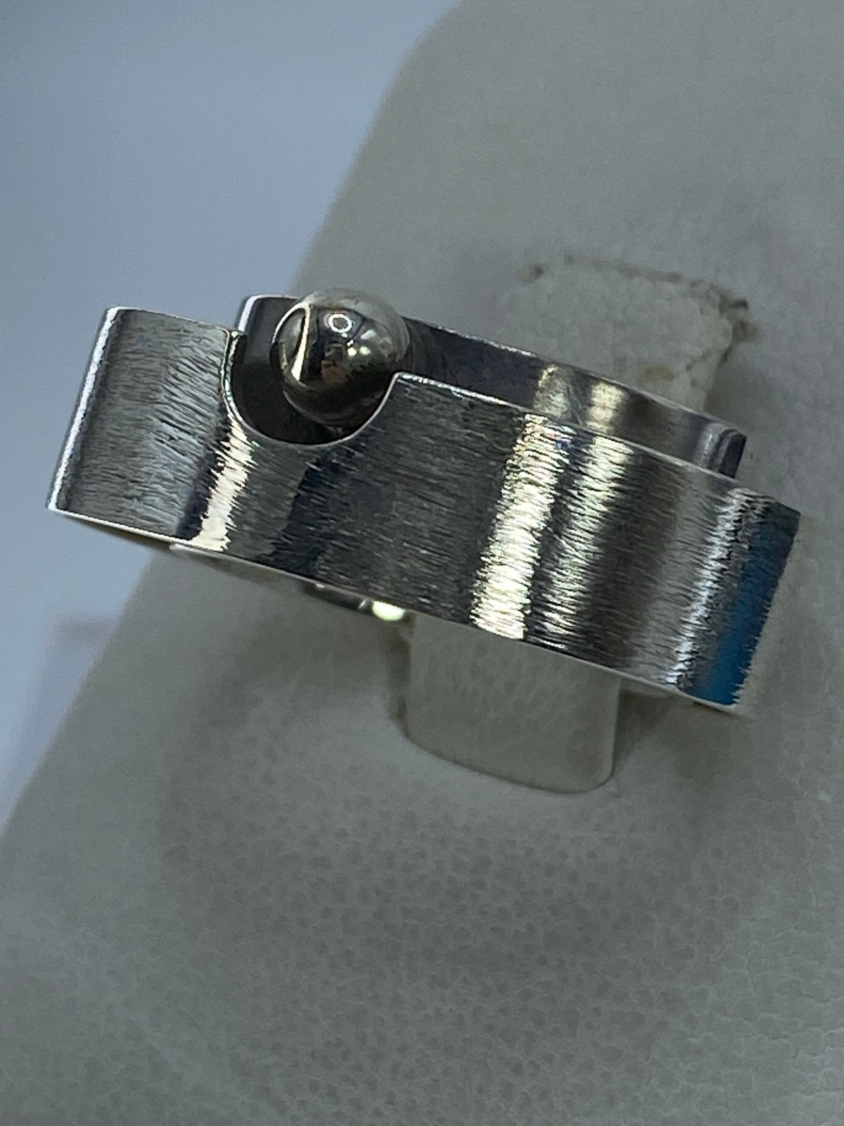Anillo de plata minimalista en la mano, mostrando acabado pulido