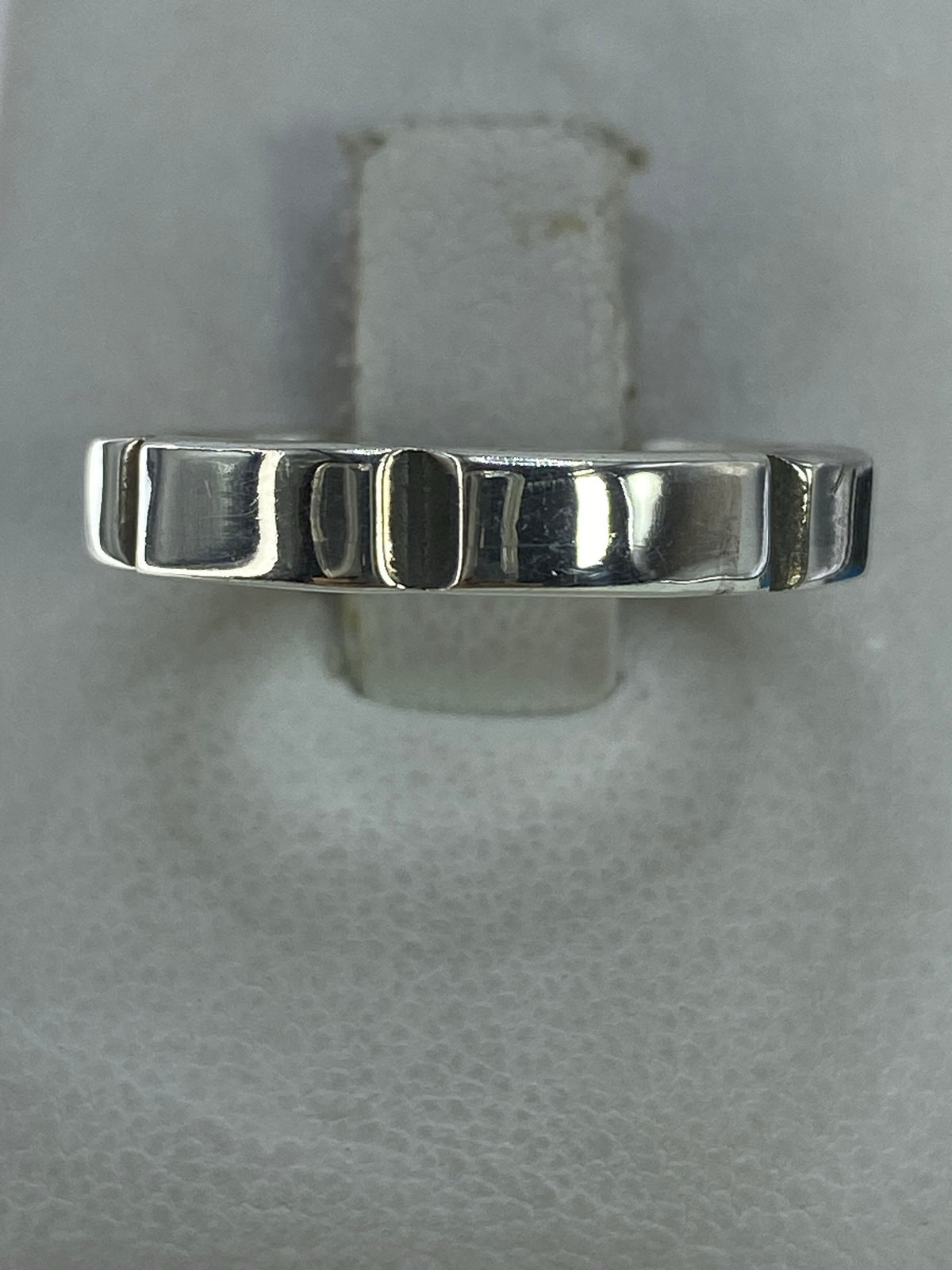 Anillo de plata minimalista con patrón geométrico en el dedo