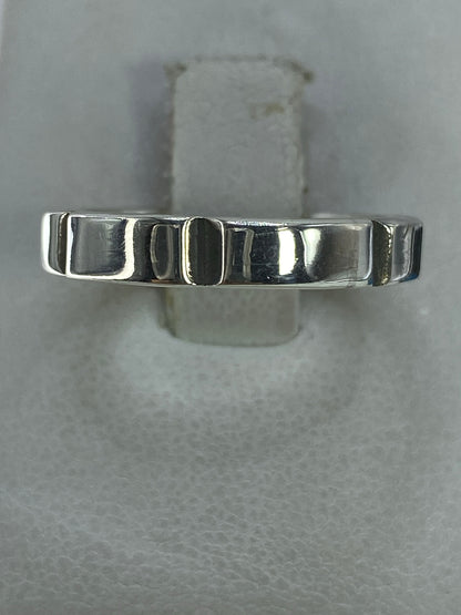 Anillo de plata minimalista con patrón geométrico en el dedo