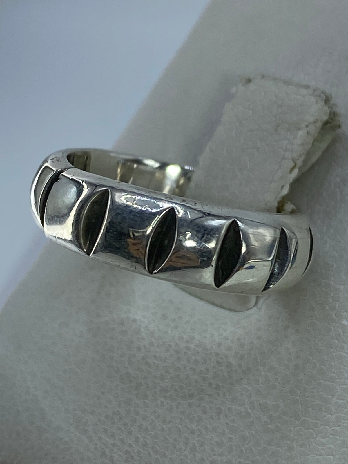 Anillo en plata Taxco con detalles en relieve colocado en mano mostrando el acabado pulido