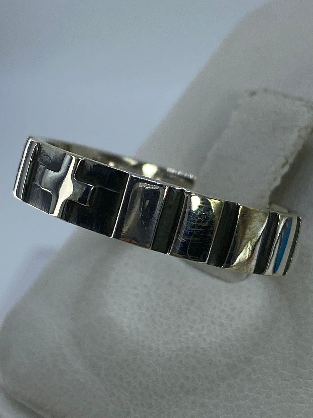 Detalle lateral del anillo mostrando el diseño minimalista y acabado pulido satinado