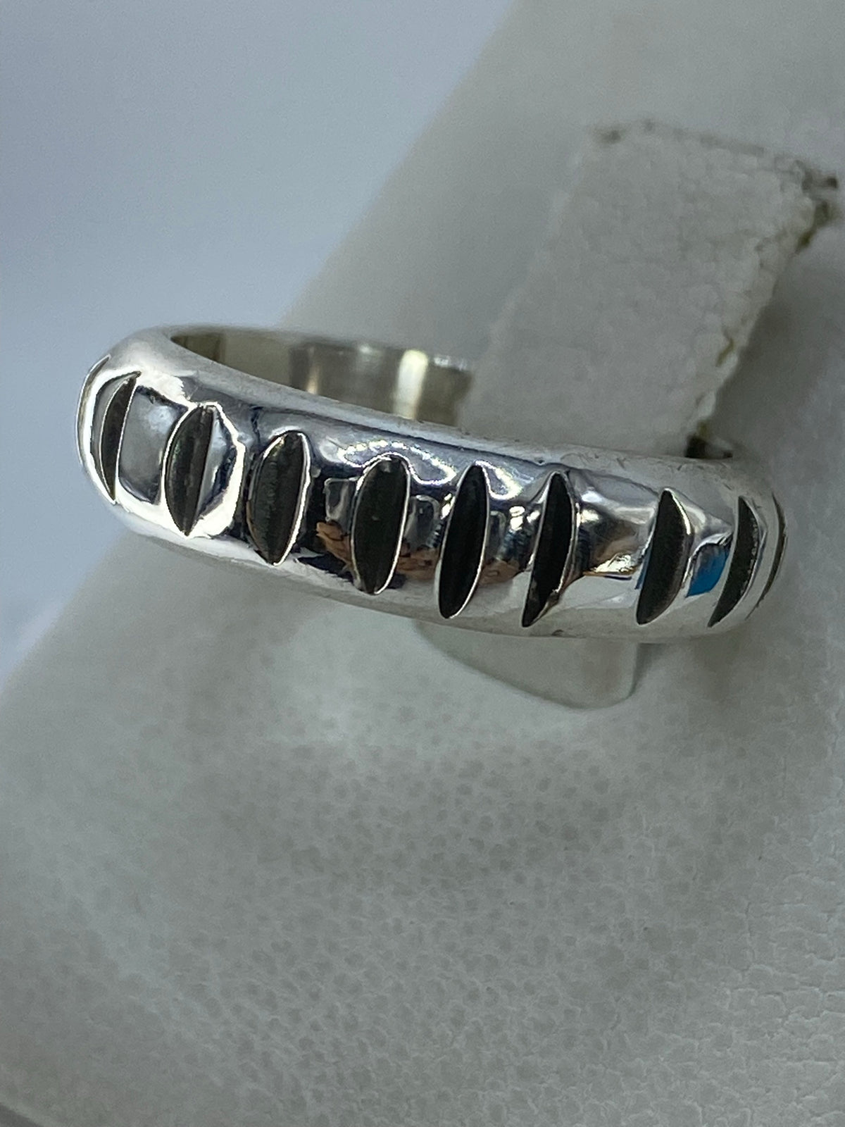 Anillo de plata con diseño de líneas sobre fondo blanco