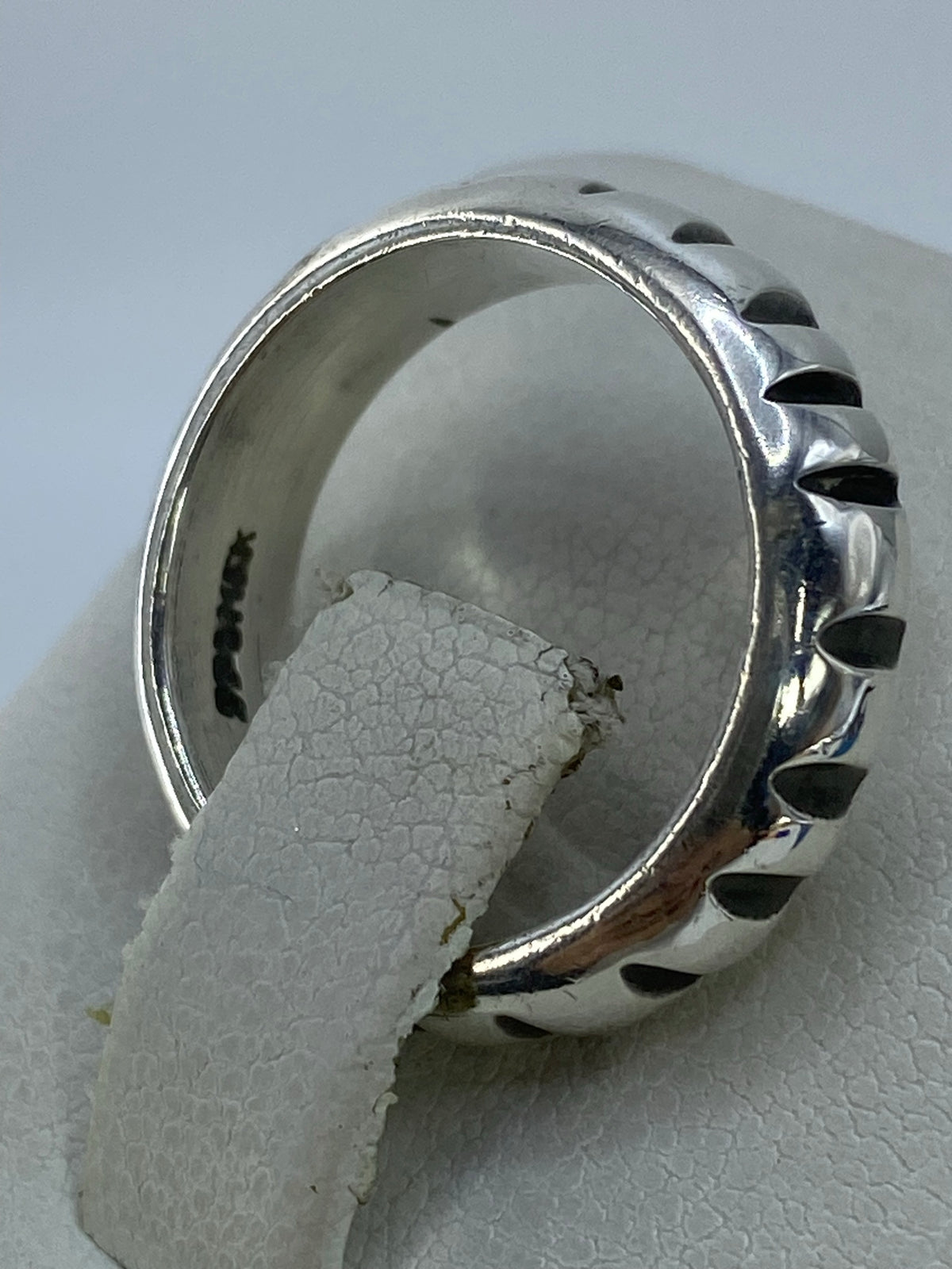 Anillo puesto en dedo mostrando cómo refleja la luz en cada pico