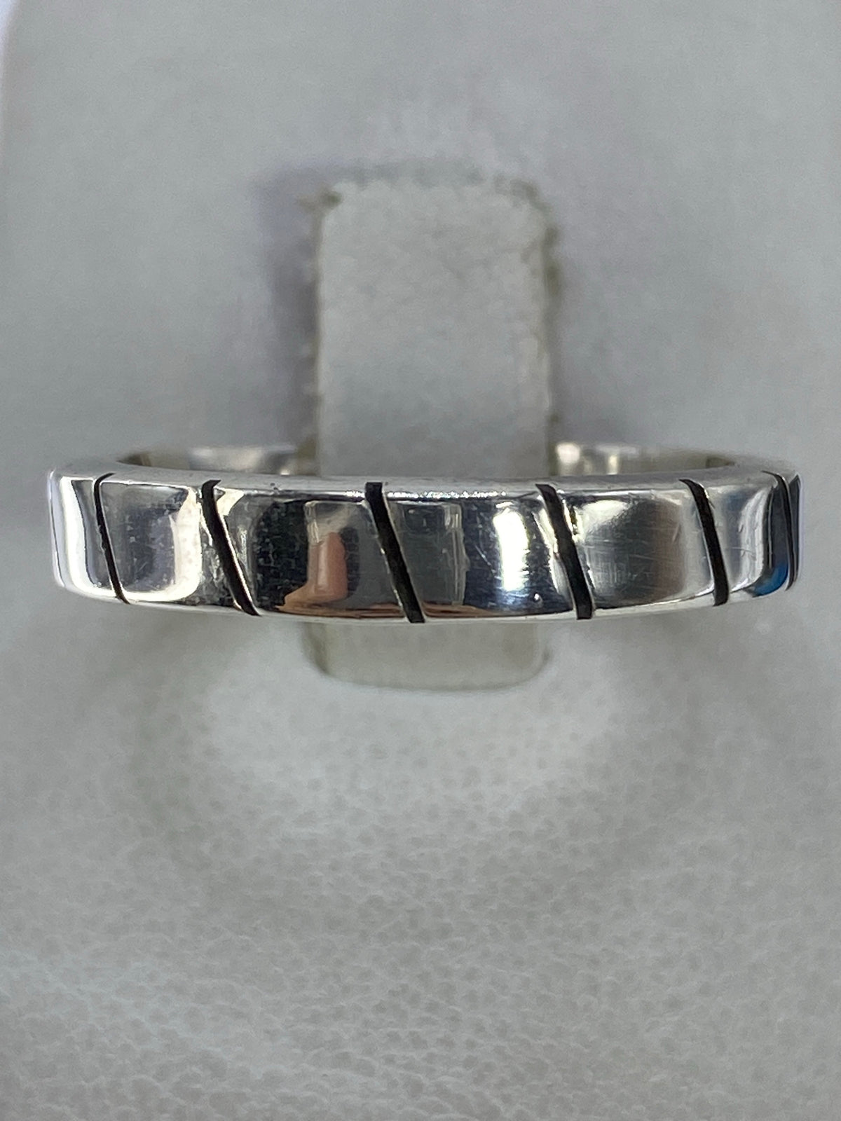 Anillo de plata 925 con eslabones geométricos pulidos en la mano de un hombre