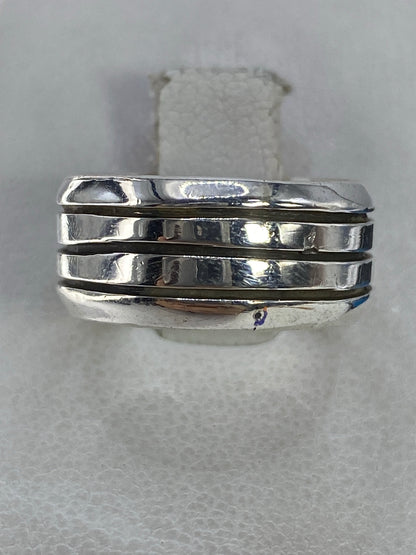 Anillo de plata triple banda pulida en la mano, vista frontal