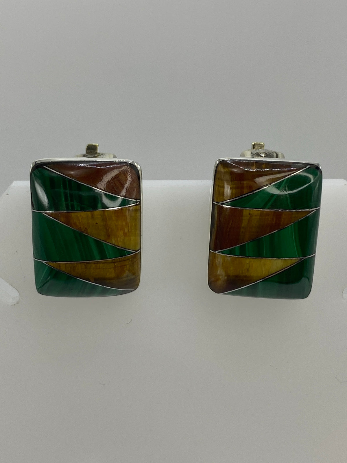 Par de aretes de plata con malaquita verde y ojo de tigre cafe sobre fondo blanco
