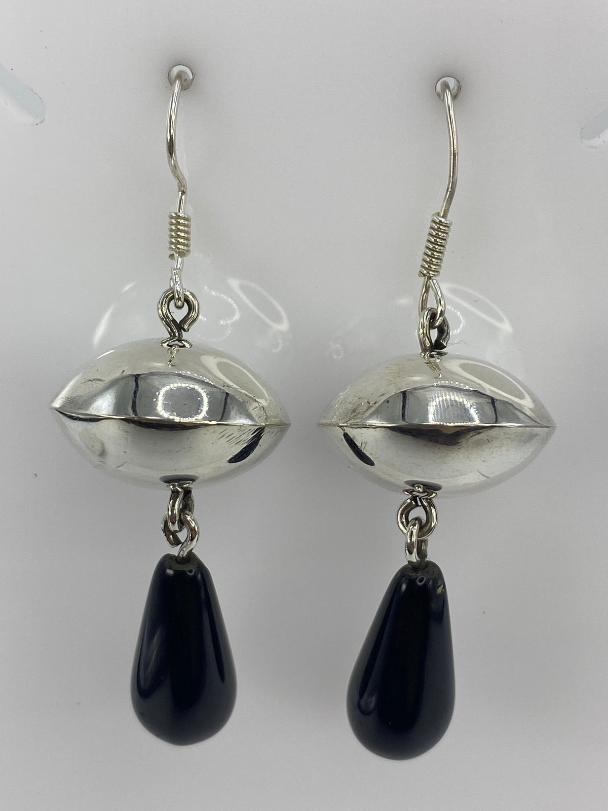 Par de aretes de plata con ónix negro en diseño esfera, largo 6 cm, visto de frente