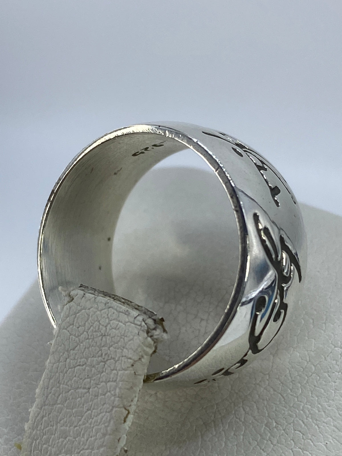 Detalle lateral del anillo mostrando el grabado profundo y el acabado pulido