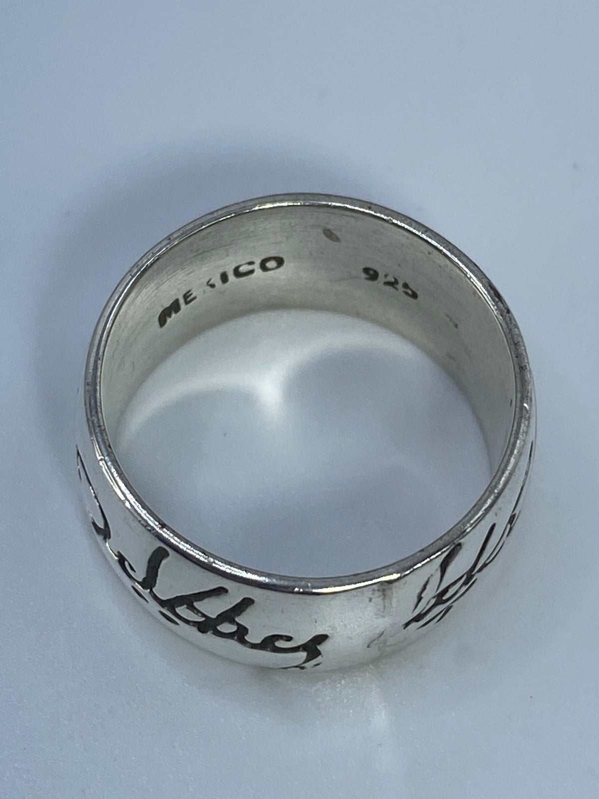 Anillo de plata sobre fondo blanco con marca del Quinto 925 visible en el interior