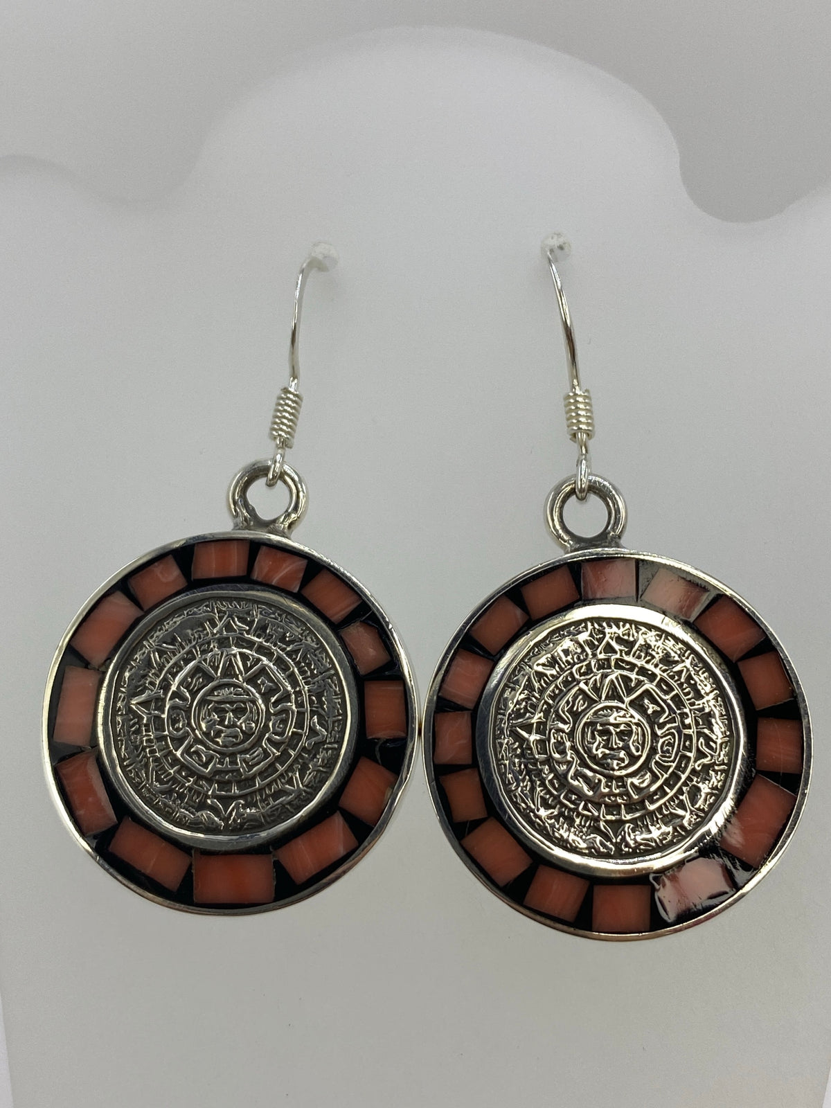 Par de aretes de plata 925 con coral rosa y diseño del Calendario Azteca, colgando de ganchos de plata