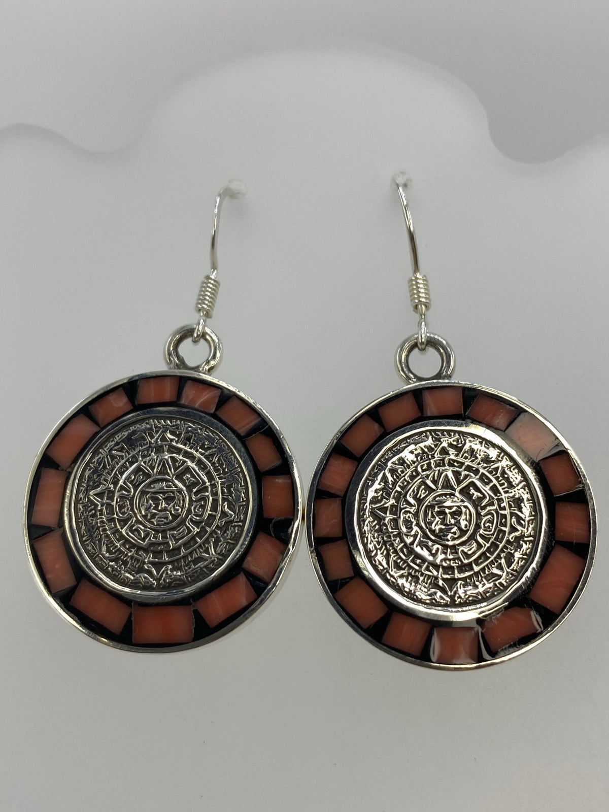 Detalle frontal del Calendario Azteca en plata con incrustación de coral rosa en los bordes