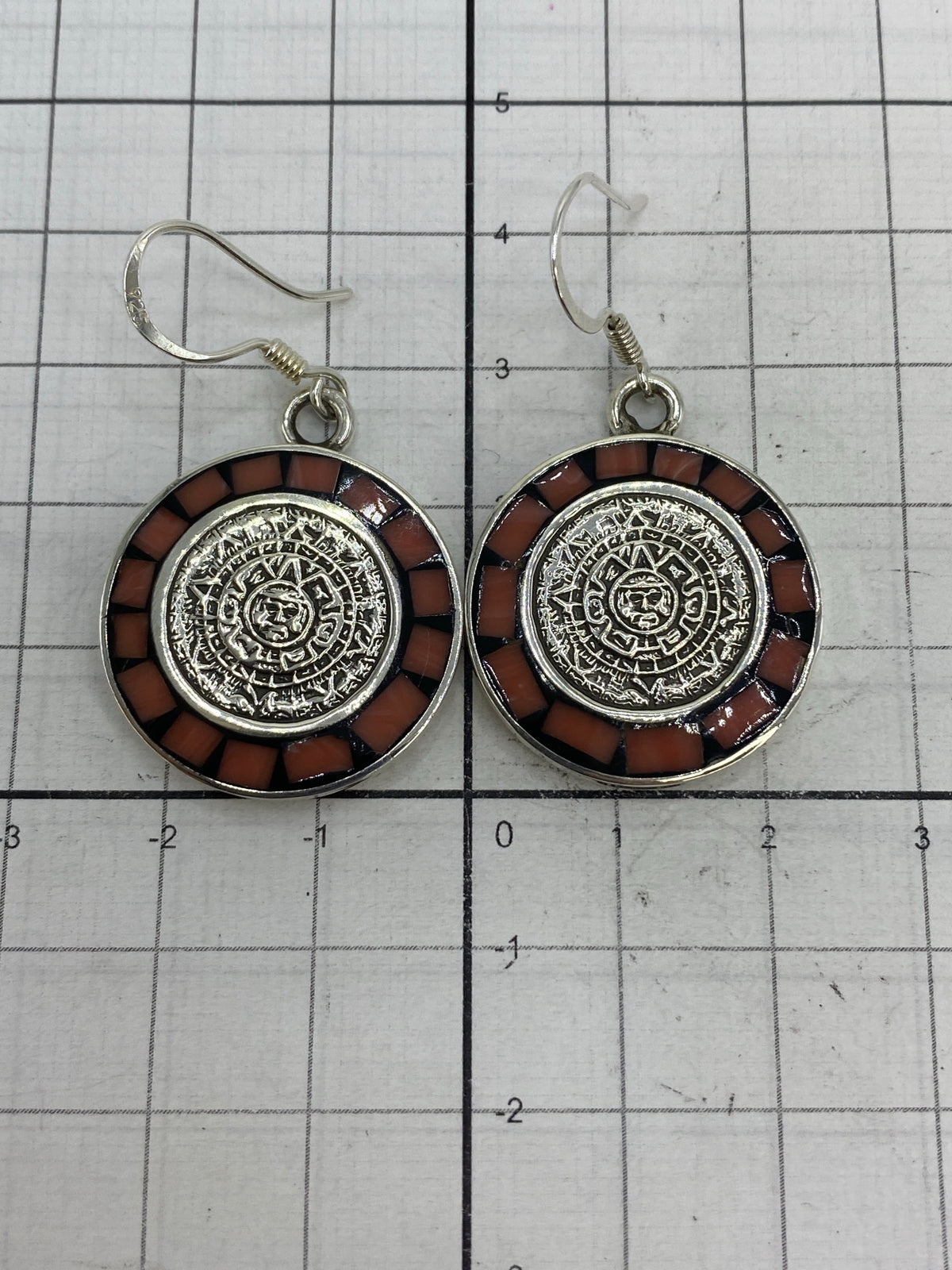 Aretes sobre fondo blanco con marca de autenticidad MEXICO 925 en la parte posterior