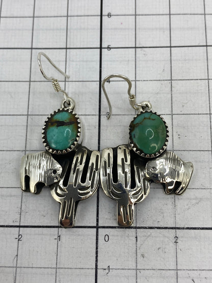Aretes sobre regla de medición mostrando largo de 4.9 cm y ancho de 2.4 cm