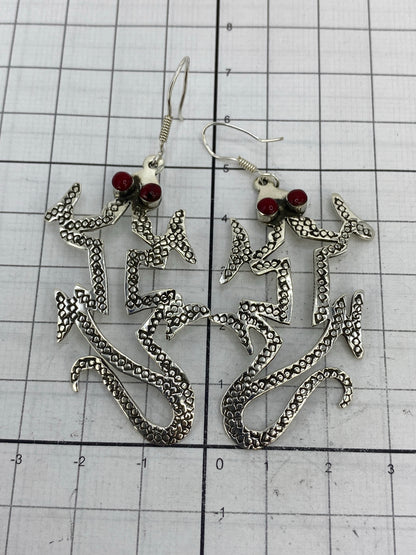 Par de aretes de plata con coral rojo sobre escala de centímetros