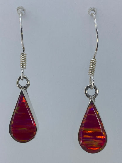 Aretes de plata con ópalo de fuego rosa en forma de gota, colgando en la oreja