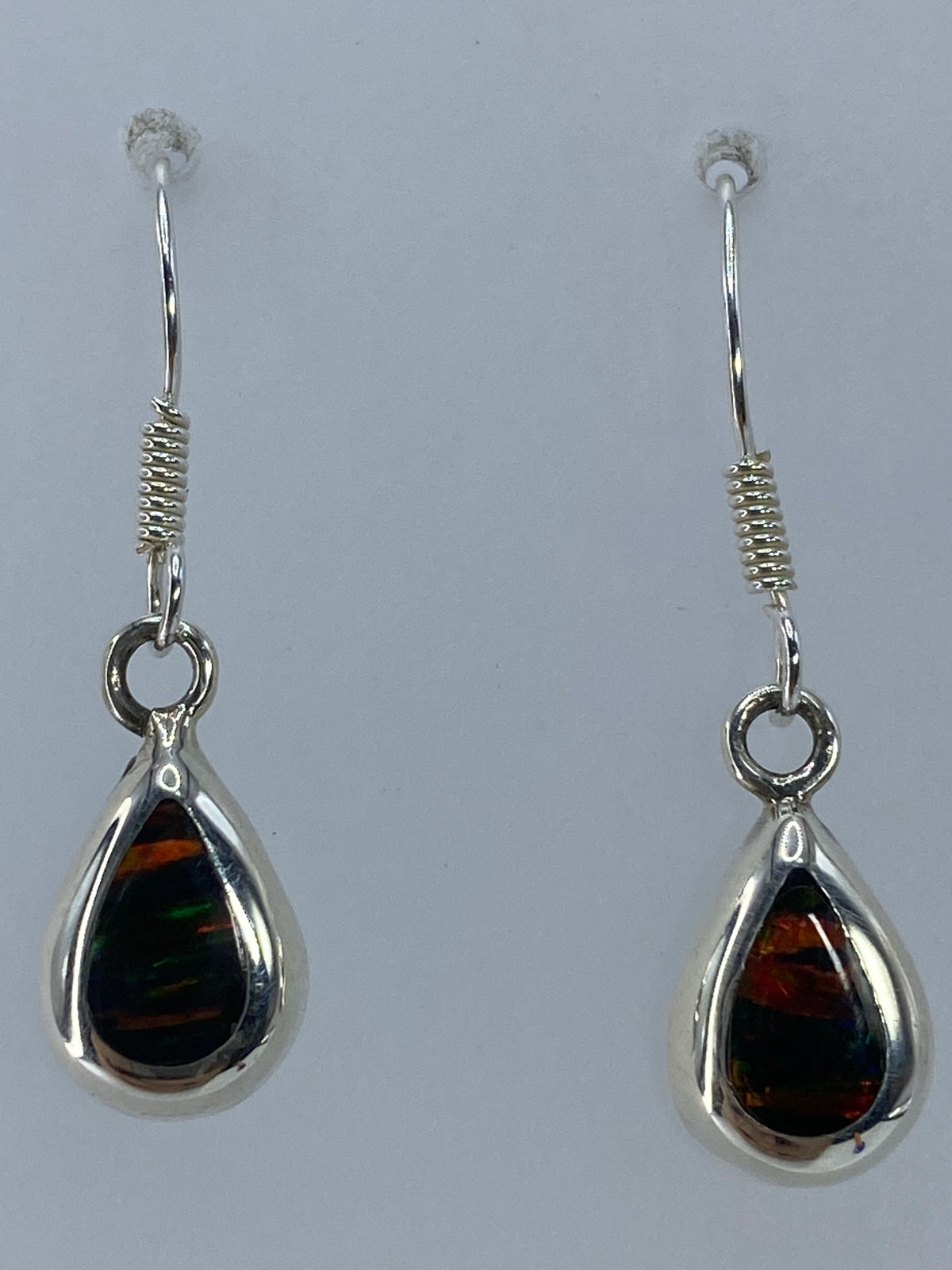 Aretes de ópalo sobre fondo blanco mostrando el Quinto 925 en la base