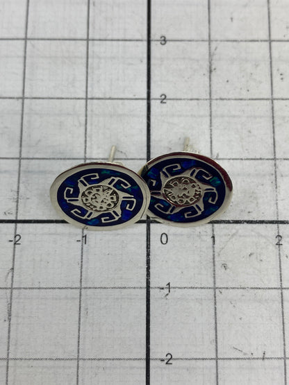 Aretes pesados en balanza de precisión, mostrando 1.06 gramos