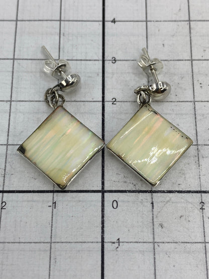 Aretes sobre regla de centímetros confirmando las medidas 3 cm × 1.7 cm por pieza