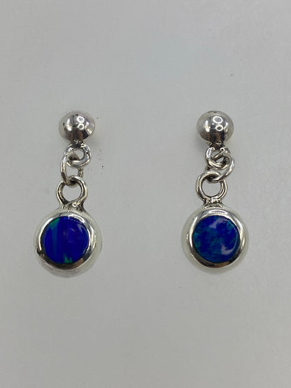 Detalle del engaste de piedra a mano en arete de ópalo azul