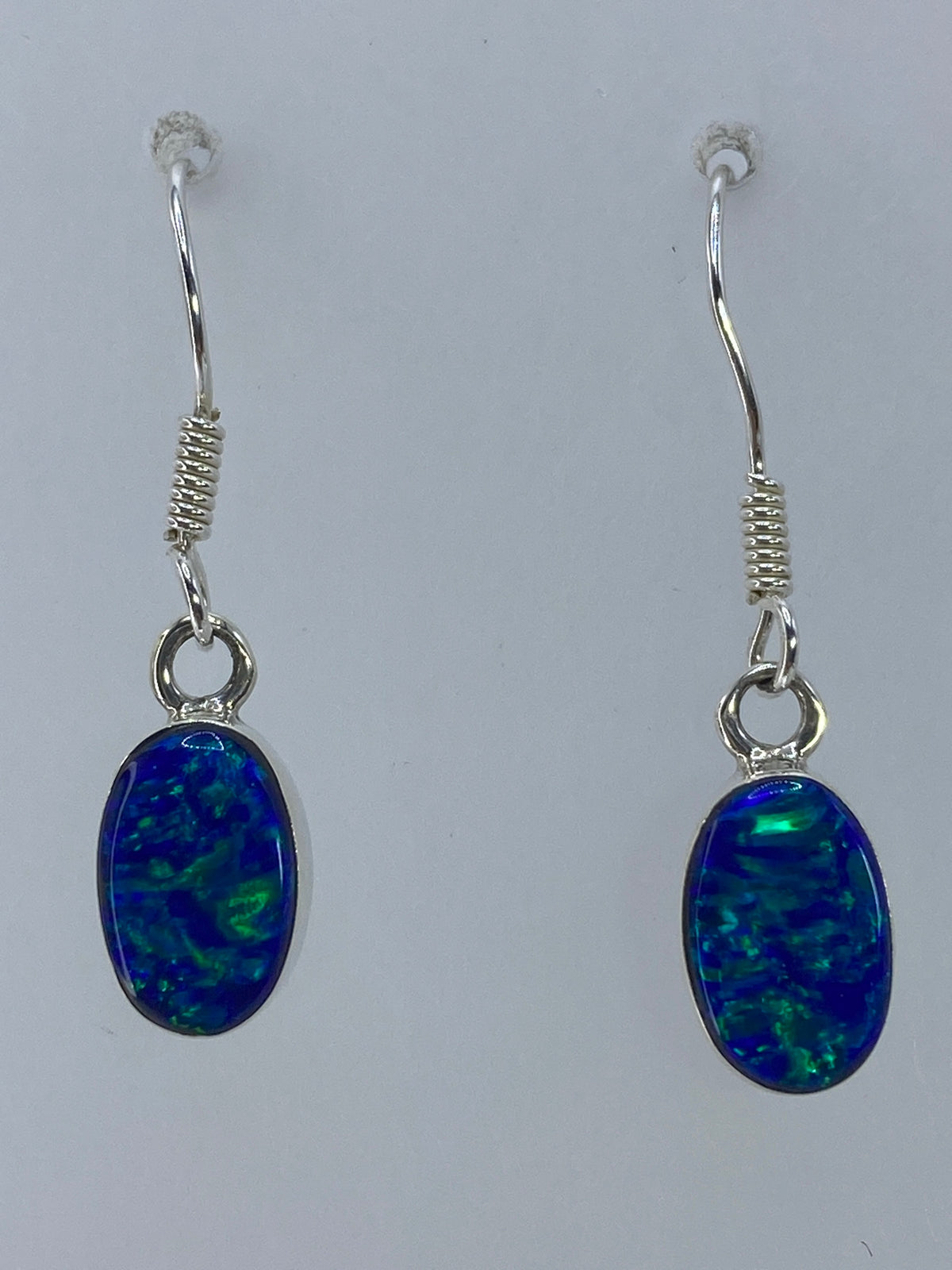 Aretes de plata 950 con ópalo de fuego verde, vista frontal del par completo