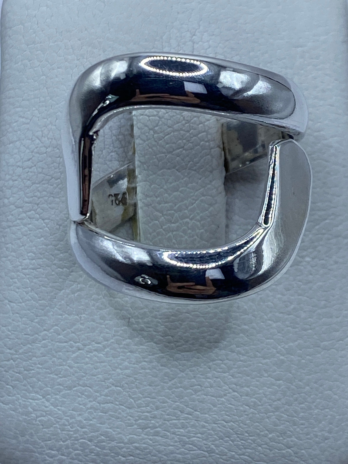 Anillo de plata calado geométrico en la mano de una mujer
