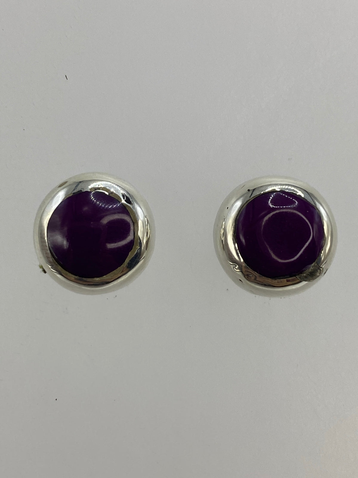 Par de aretes sobre regla mostrando tamaño de 1.2 cm