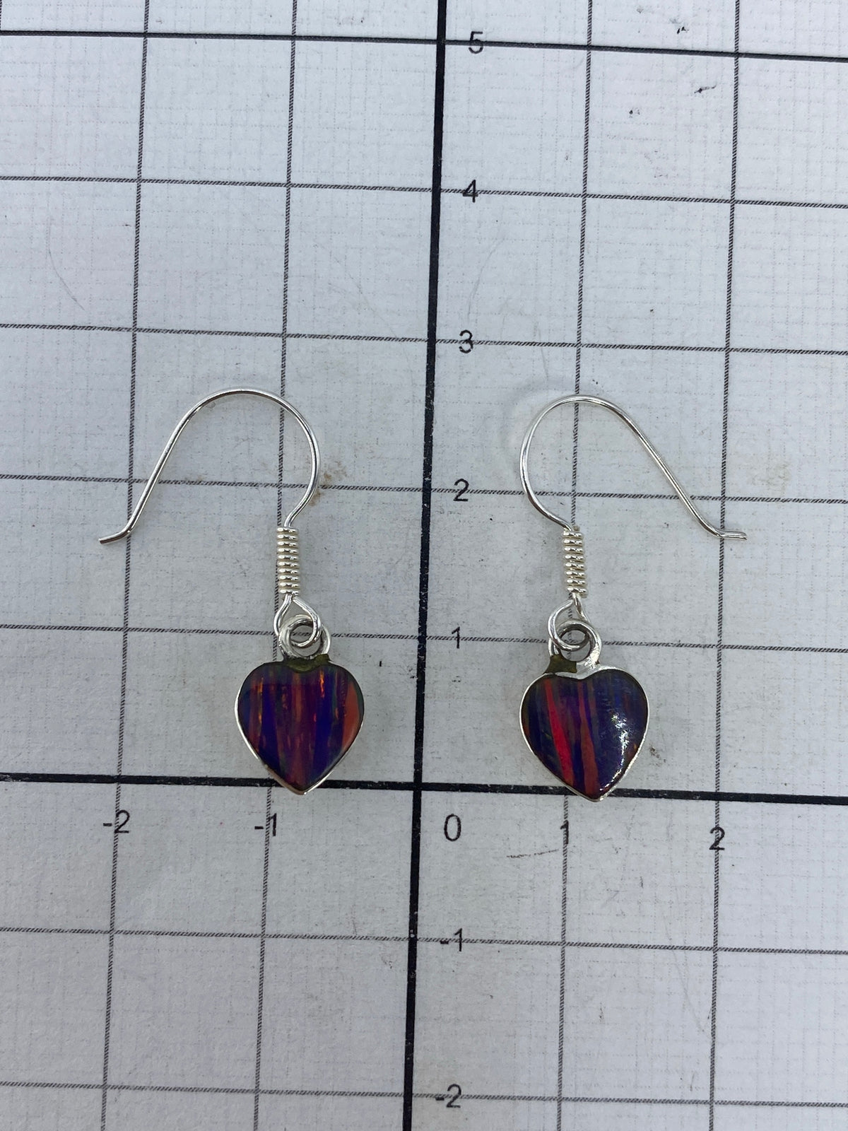 Aretes sobre fondo blanco — marca del Quinto 925 visible en la plata
