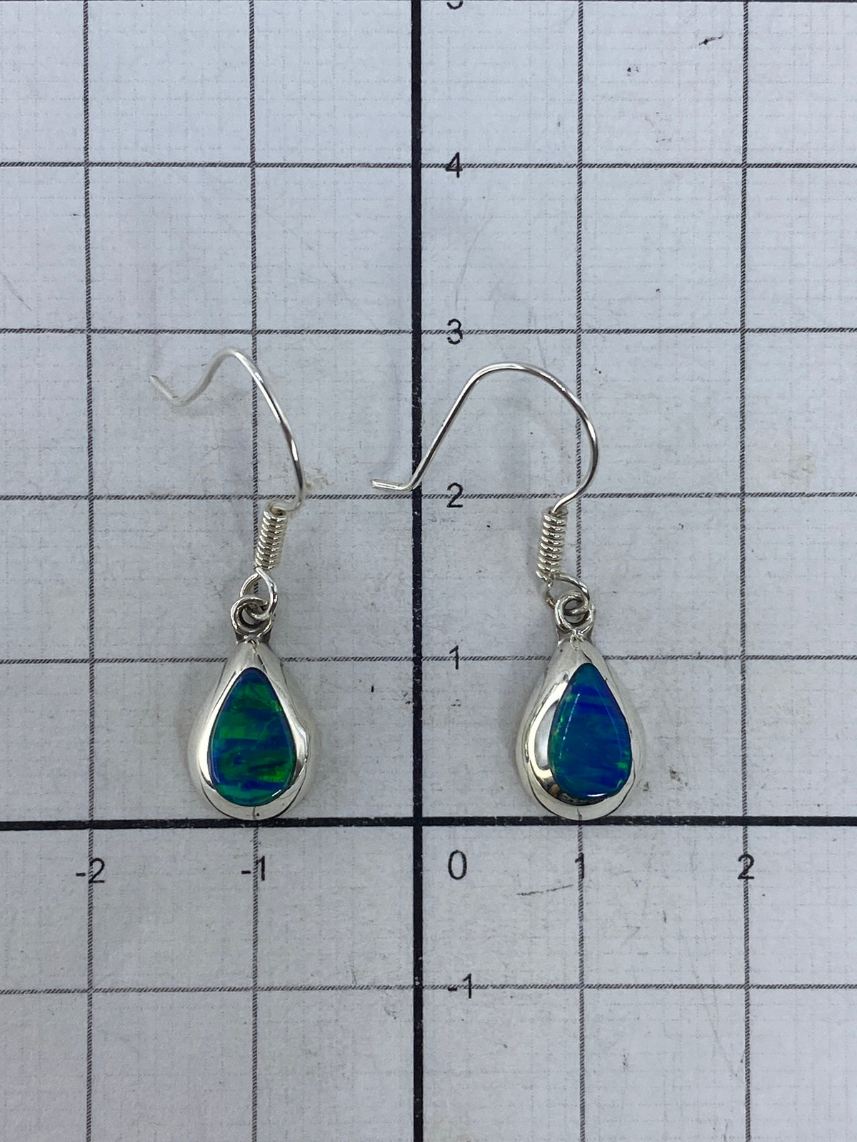Aretes sobre fondo gris mostrando el Quinto 925 grabado en la plata