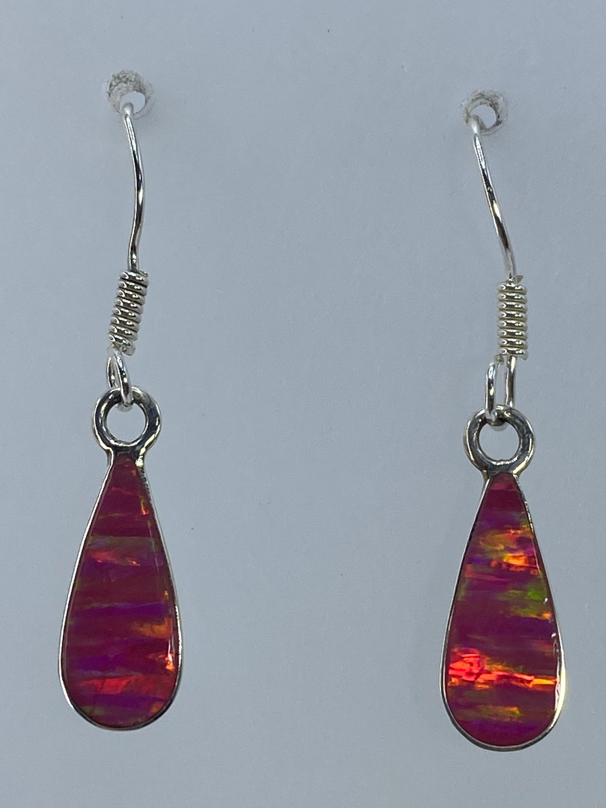 Detalle del engaste de ópalo en plata — vetas de rojo y naranja visibles
