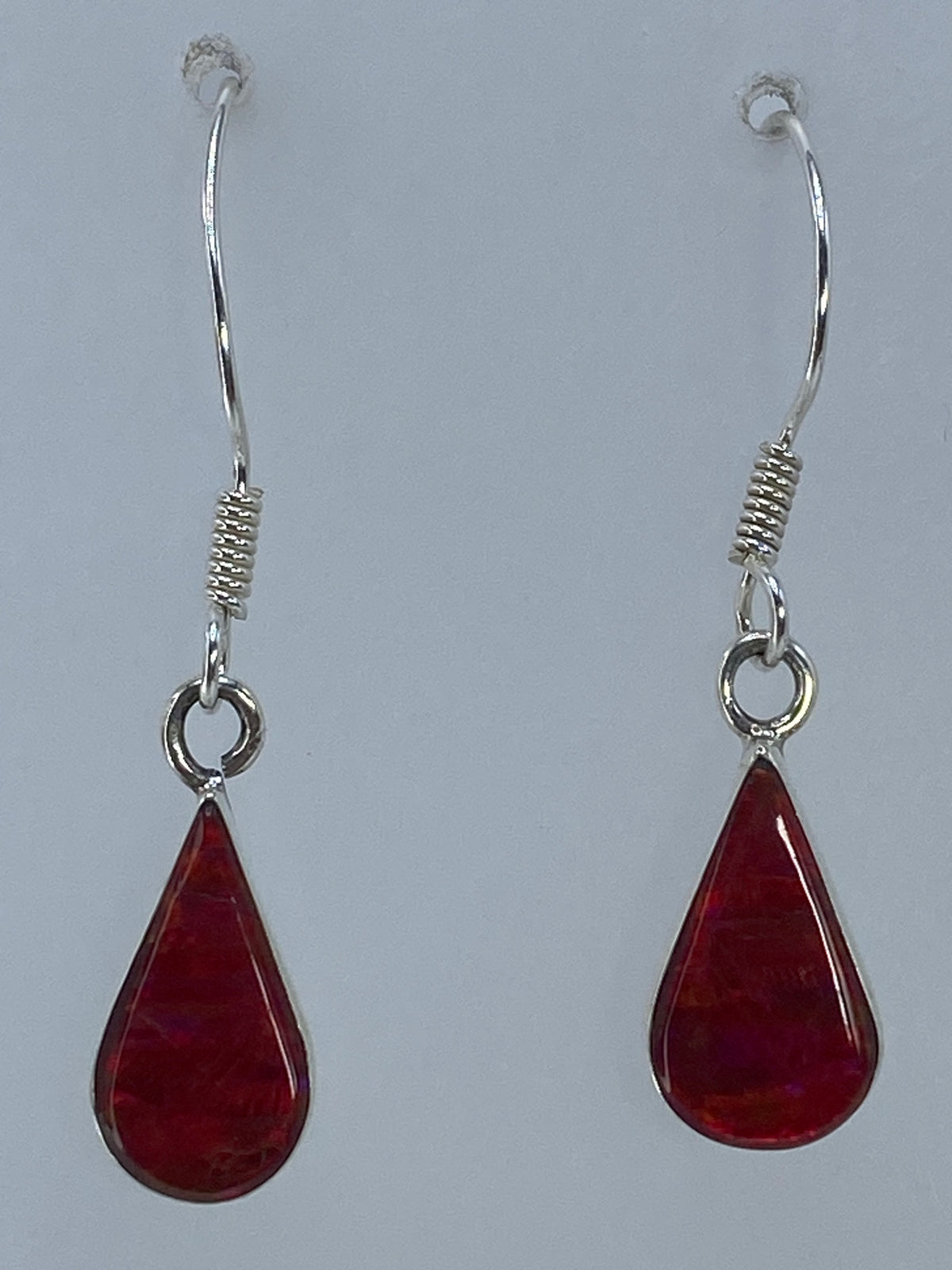 Aretes sobre regla de medida mostrando largo de 3.4 cm