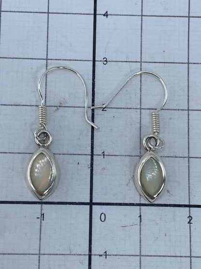 Aretes sobre escala de medida mostrando largo de 2.9 cm por pieza