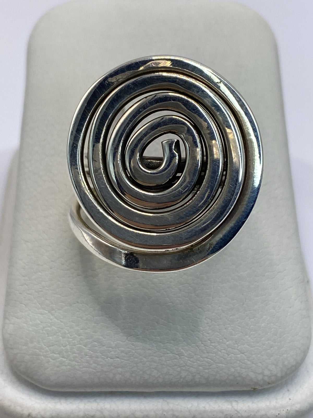 Anillo de plata calado con espiral concéntrica en la mano de una mujer