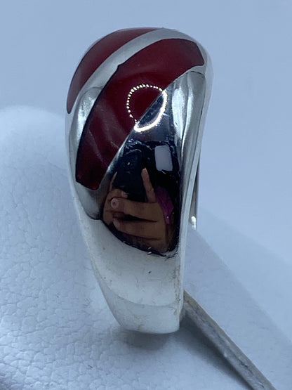 Detalle lateral del anillo mostrando la banda de plata pulida y el coral incrustado