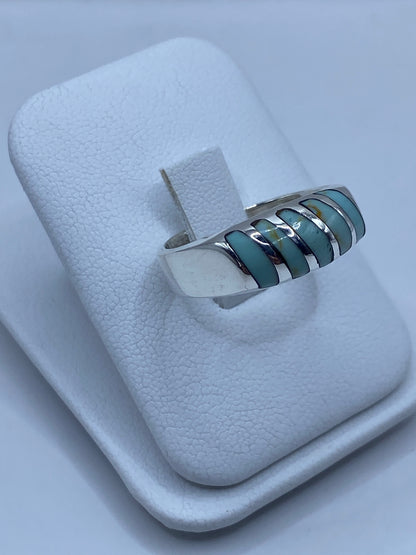 Detalle lateral del anillo mostrando el engaste manual de la turquesa y el pulido de la plata