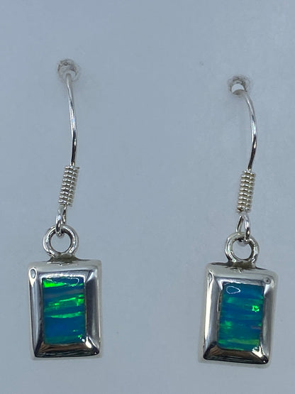 Aretes sobre regla mostrando 3 cm de largo — visión frontal