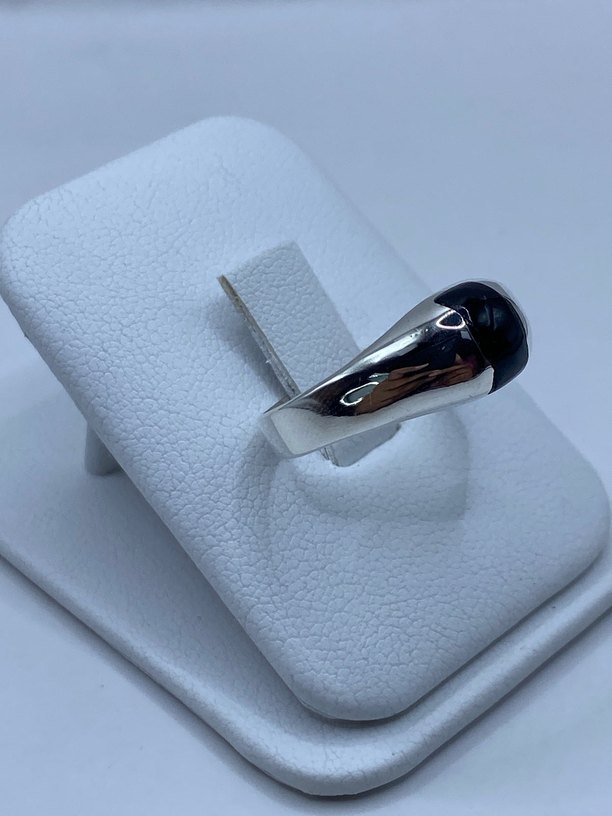 Detalle lateral del anillo mostrando el engaste de la piedra negra en plata pulida