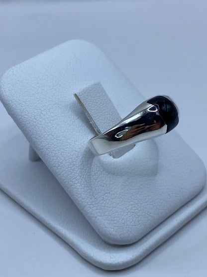 Detalle lateral del anillo mostrando el engaste de la piedra negra en plata pulida
