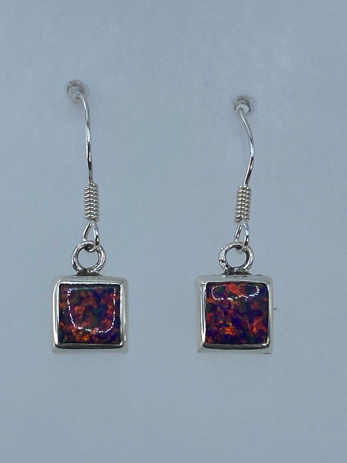Detalle del ópalo de fuego en tonos naranja, rojo y amarillo dentro del marco de plata