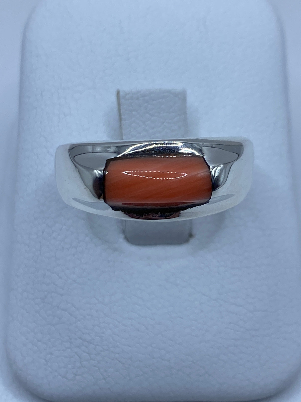 Anillo de plata 925 con coral engastado, vista frontal en soporte blanco