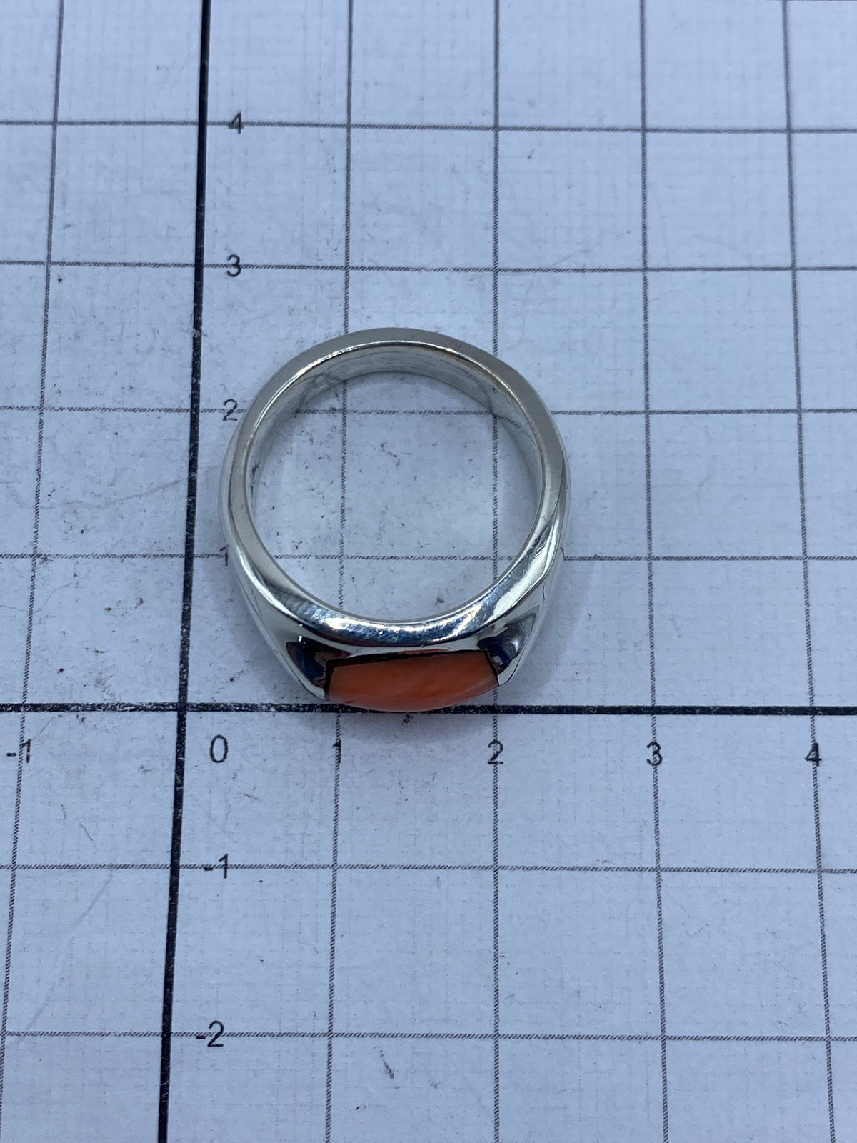 Anillo de plata sobre regla métrica, peso de 9.4 gramos visible en báscula