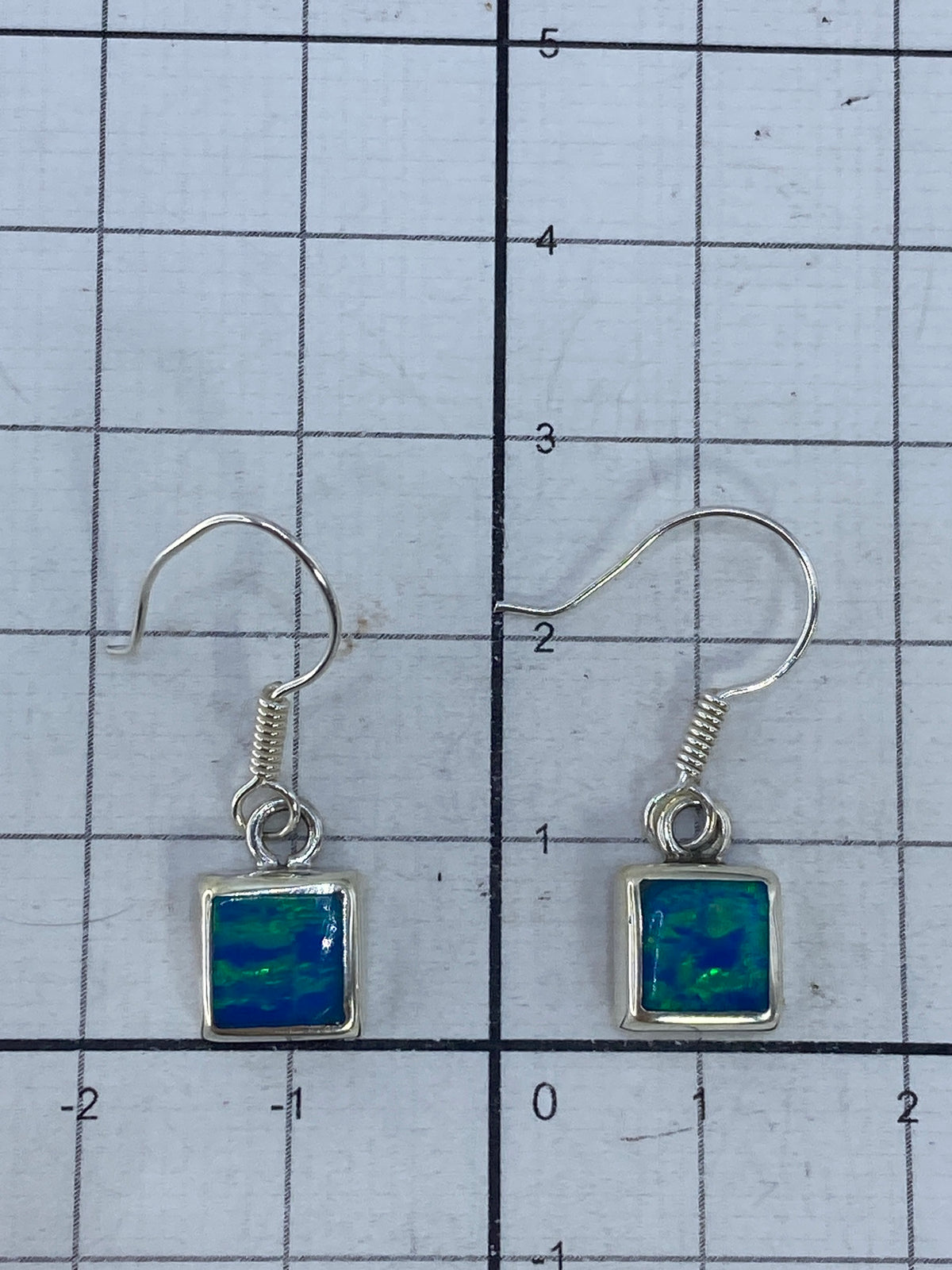 Aretes de ópalo sobre fondo blanco con marcas de Quinto 925