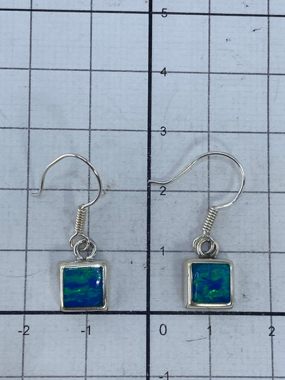 Aretes de ópalo sobre fondo blanco con marcas de Quinto 925