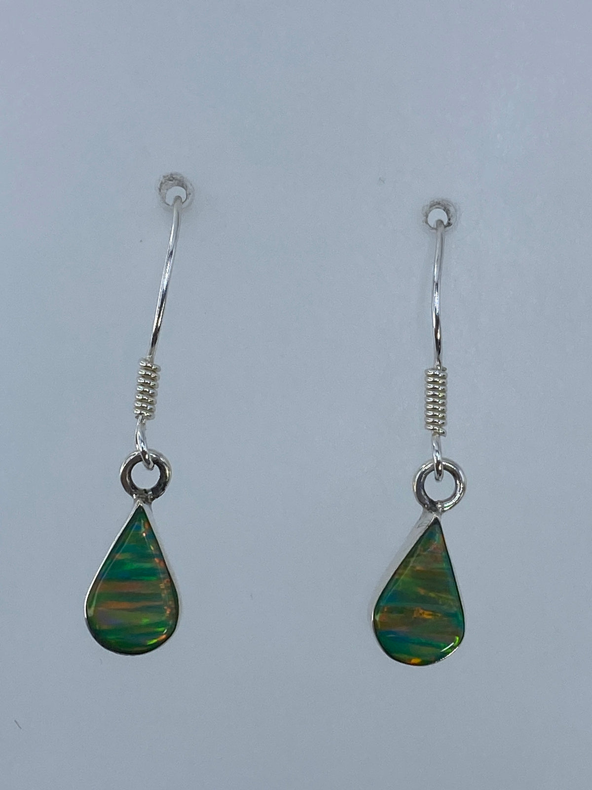 Aretes ópalo de fuego en plata 950 sobre regla métrica mostrando 3 cm de largo