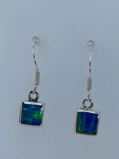 Aretes cuadrados de plata 925 mostrando el juego de colores del ópalo de fuego