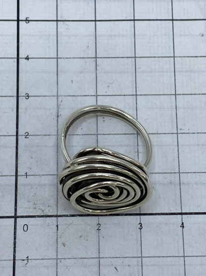 Anillo de plata con movimiento giratorio fotografiado sobre escala de milímetros